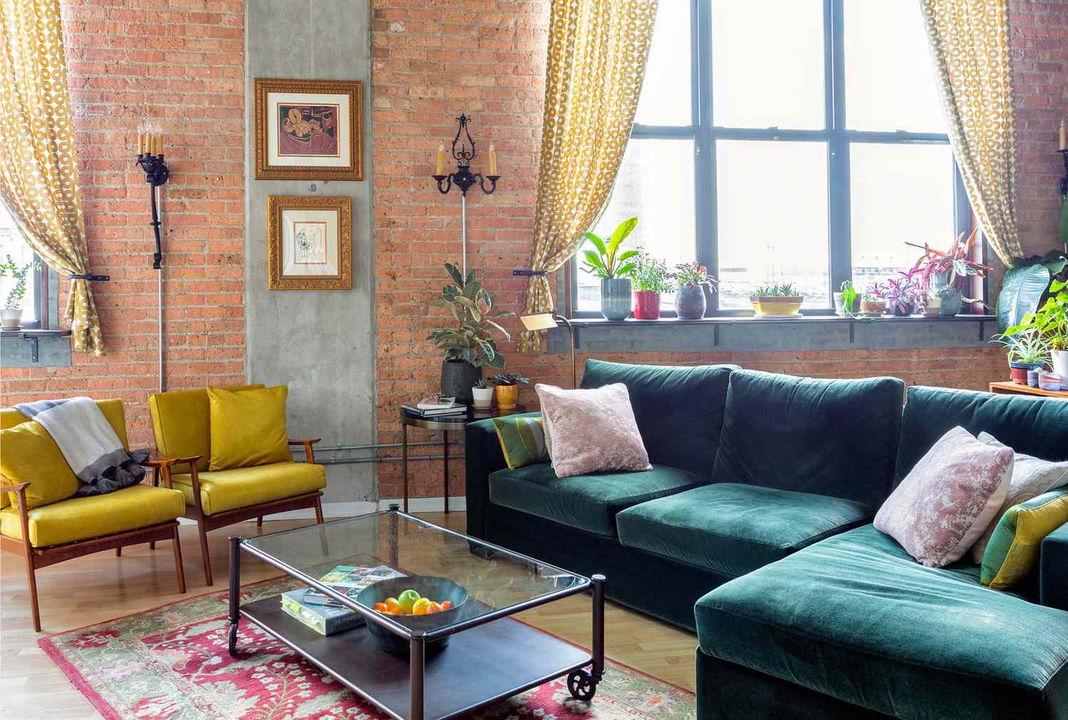 Sala de estar de tijolos expostos com sofá de veludo colorido, decoração e plantas
