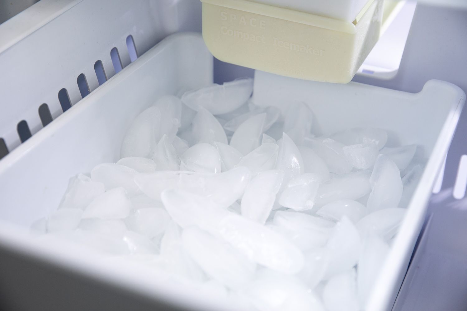 Recipiente da máquina de fazer gelo cheio de cubos de gelo