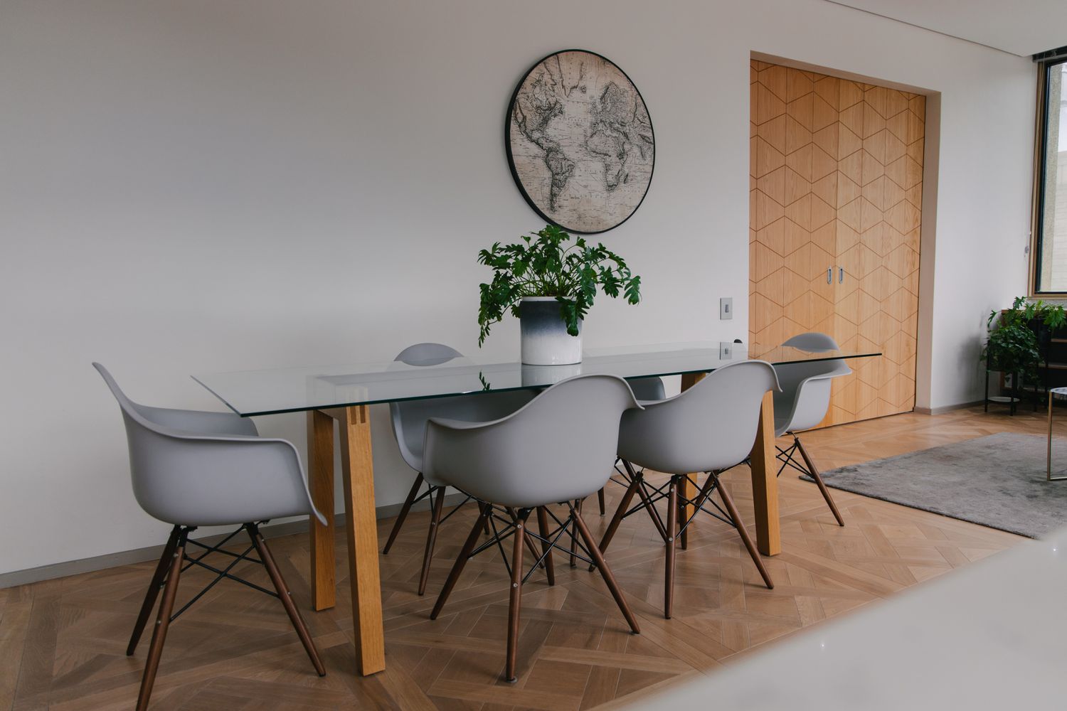 table de salle à manger avec chaises grises sur un sol en bois