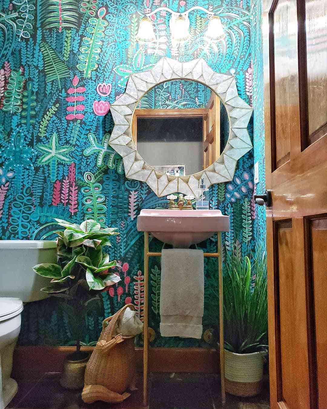 Baño con atrevido papel pintado y lavabo rosa