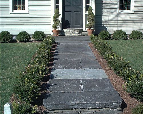 Mit Buchsbaumsträuchern gesäumter Granitweg.