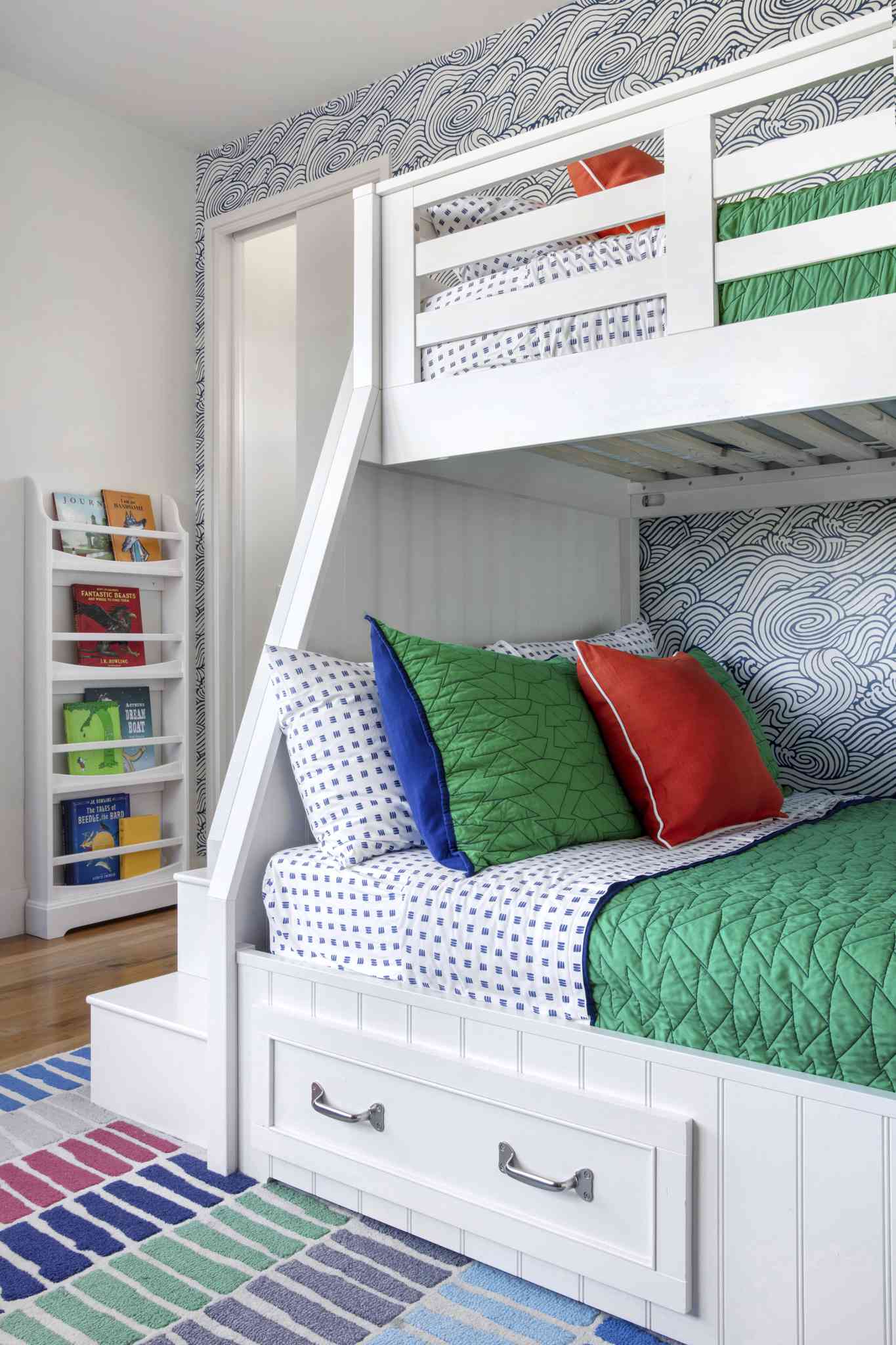 swirly blue-and-white wallpaper in this kid bedroom featuring a bunk bed and primary colors