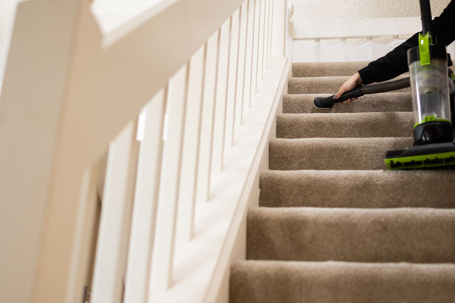 Nettoyage à l'aspirateur du haut de l'escalier avec brosse