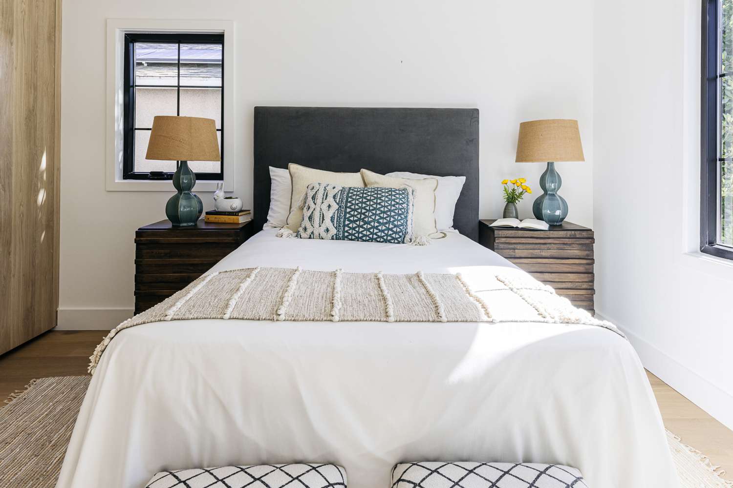 Guest bedroom with patterned throw pillow and folded throw blanket on end