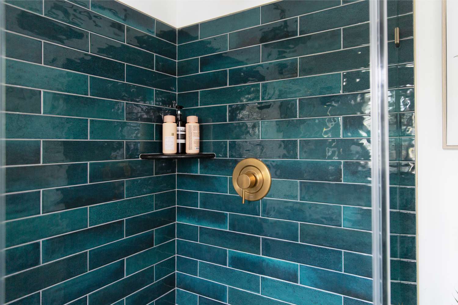 Deep teal bathroom tiles in a shower stall