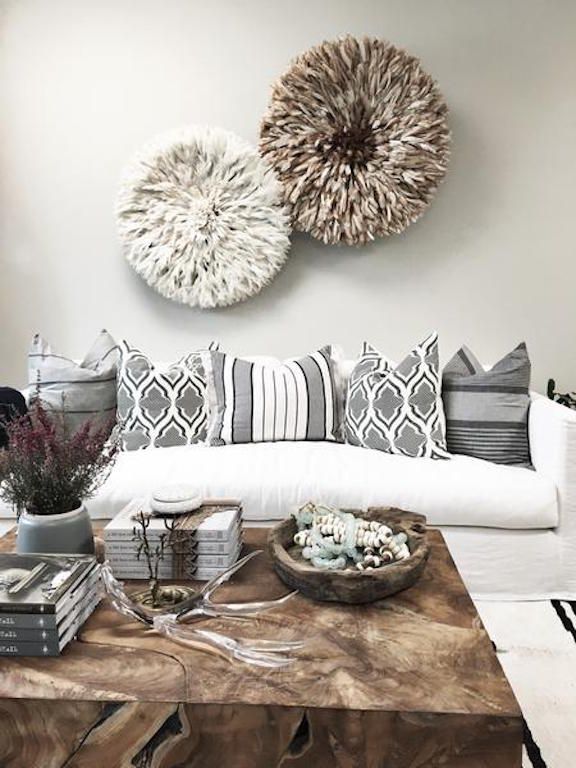 Sala com parede pintada de cogumelo, sofá branco, almofadas estampadas