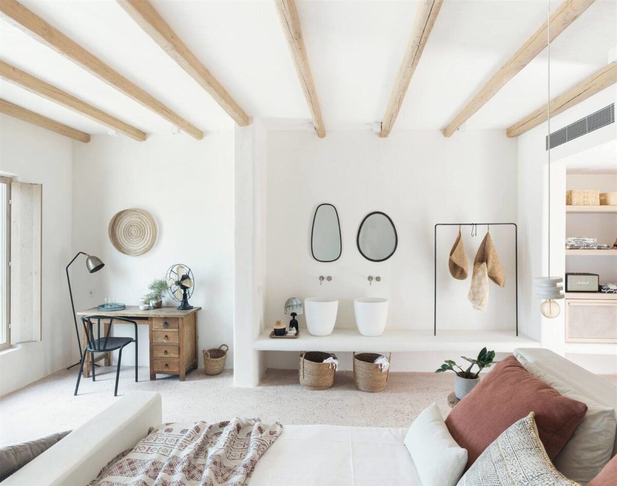 Une chambre blanche lumineuse avec des paniers de rangement.