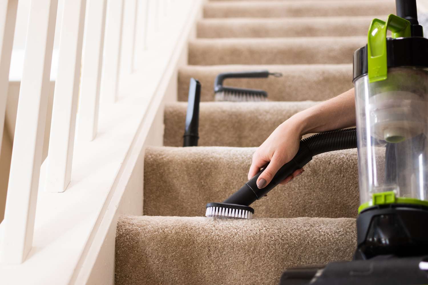 Escadas acarpetadas sendo aspiradas com mangueira de fixação em close-up