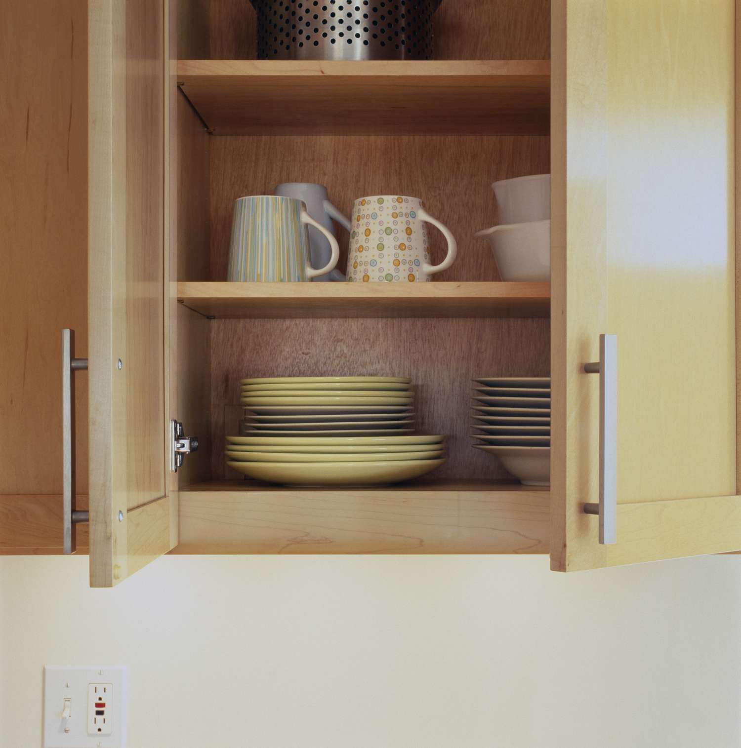 Primer plano de platos en un armario de cocina abierto.