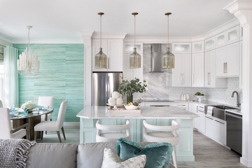 All-white modern kitchen with turquoise living room walls