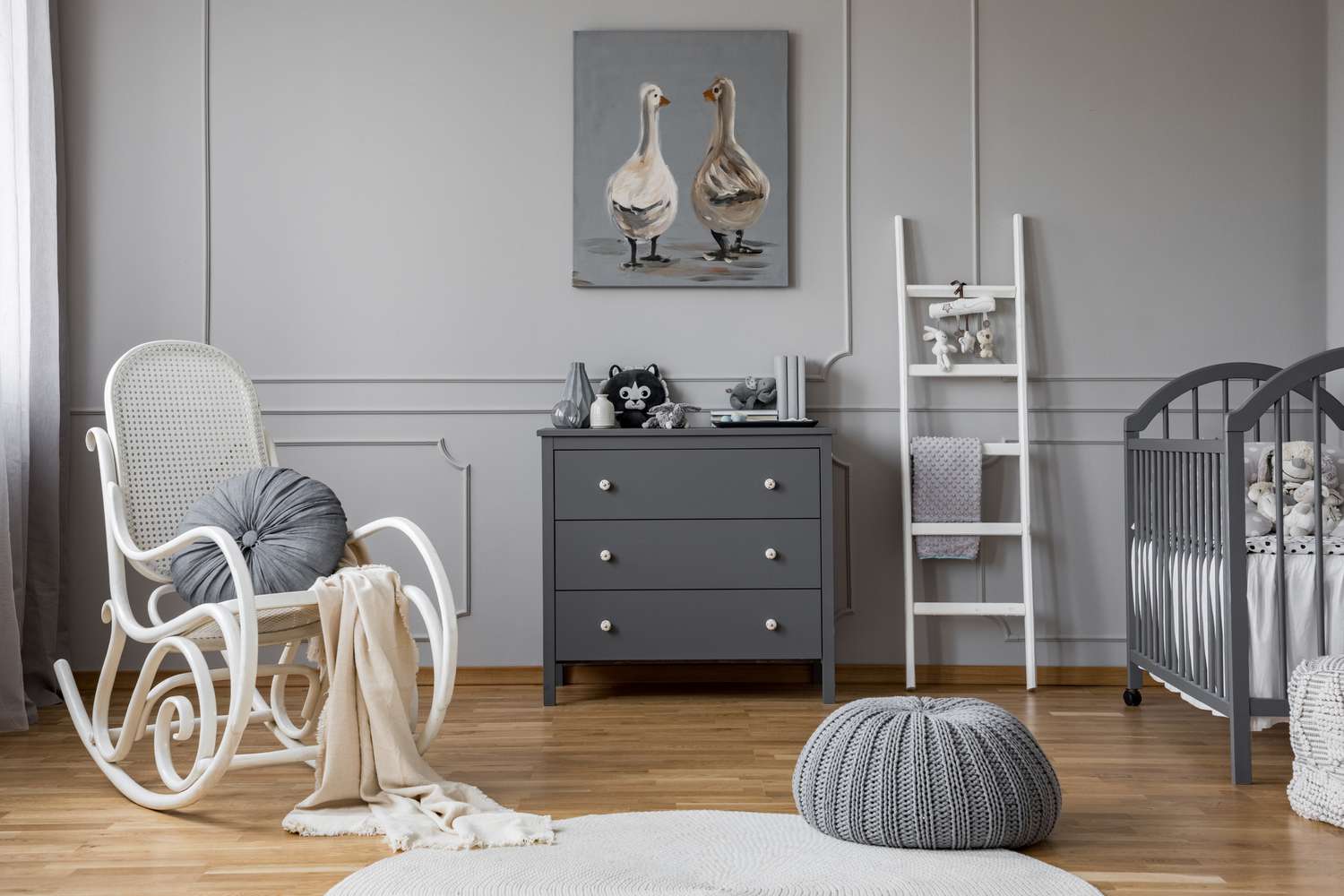 Pouf et chaise à bascule dans un intérieur de chambre de bébé gris avec échelle à côté de l'armoire. Real photo
