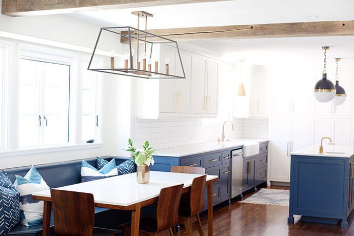 cozinha azul e branca com piso de madeira e armários brancos