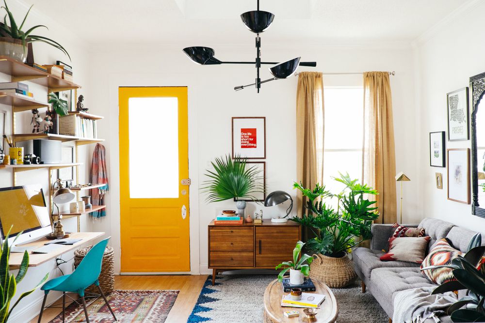 Wohnzimmer im böhmischen Stil mit mehreren Teppichen und gelben Farbtupfern