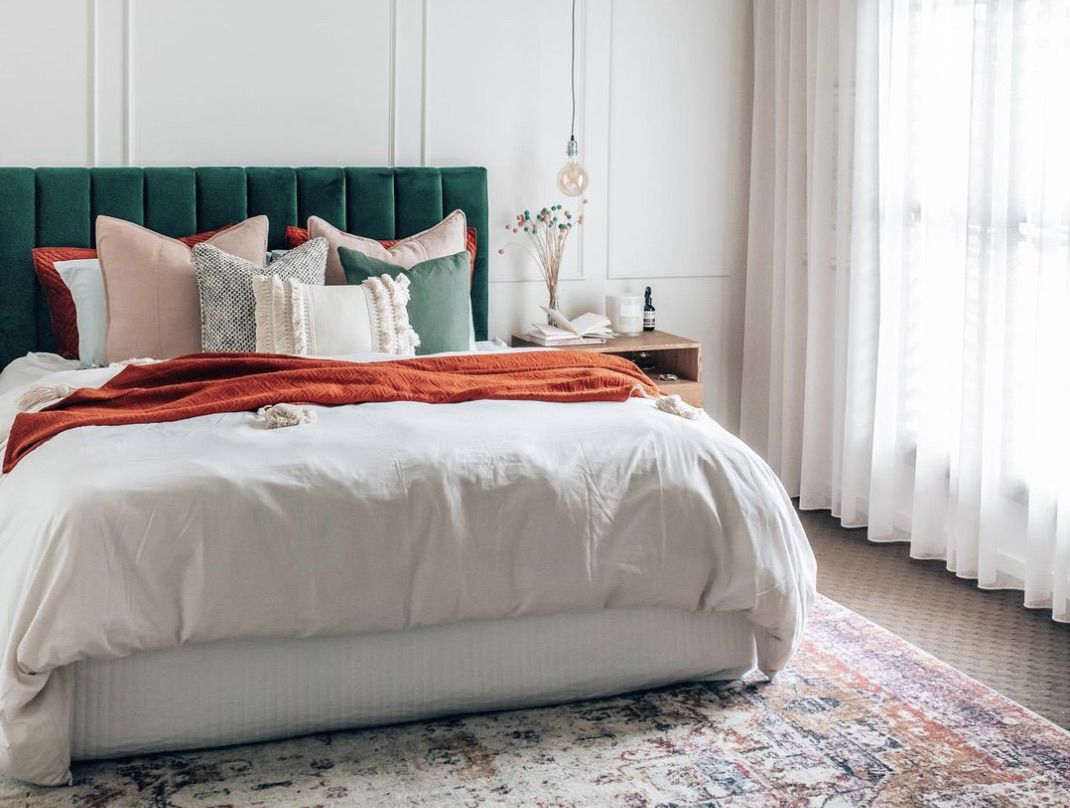 dormitorio de estilo escandinavo con naranja quemado, verde oscuro y alfombra de acento patterened