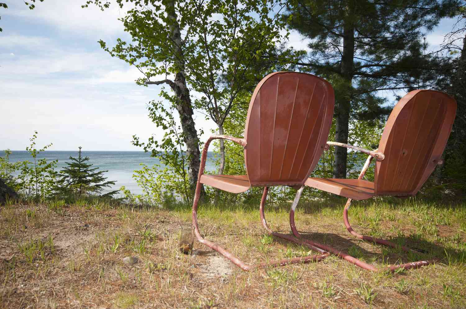cadeiras de gramado laranja retrô com vista para um lago