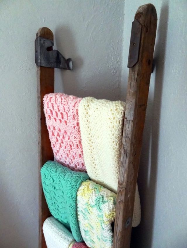 Escada de madeira vintage usada para expor cobertores no quarto do bebê