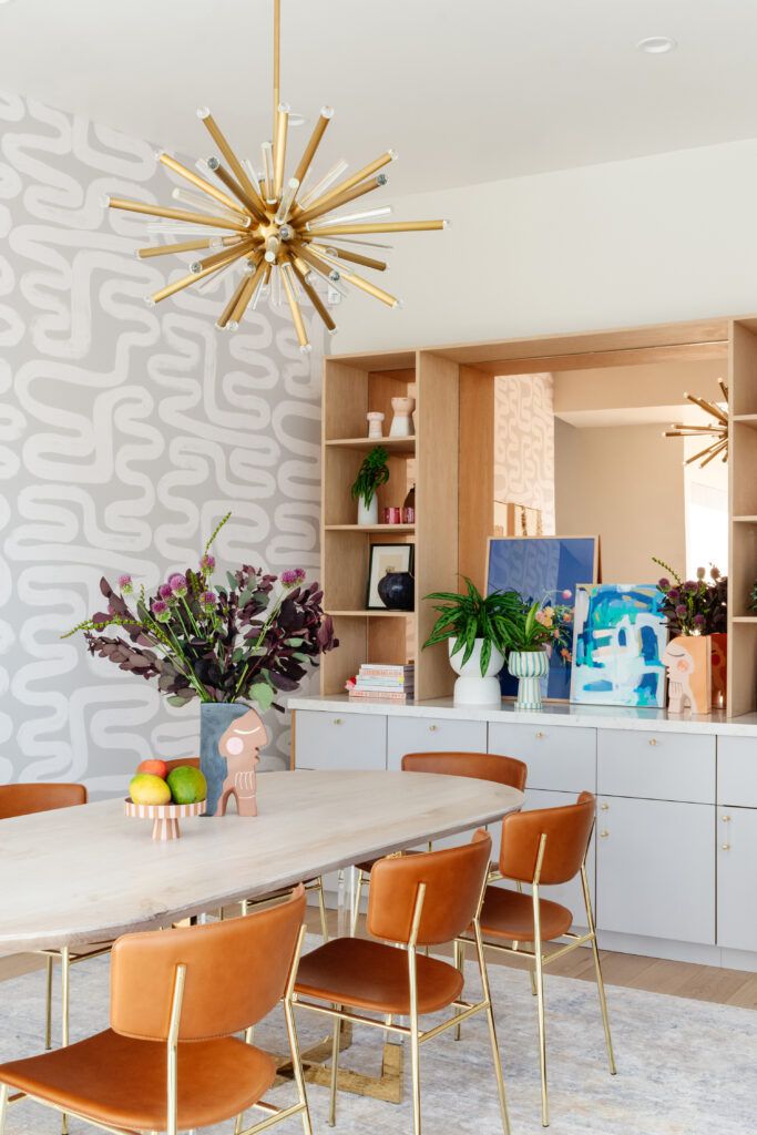 sala de jantar com papel de parede em espiral e obras de arte