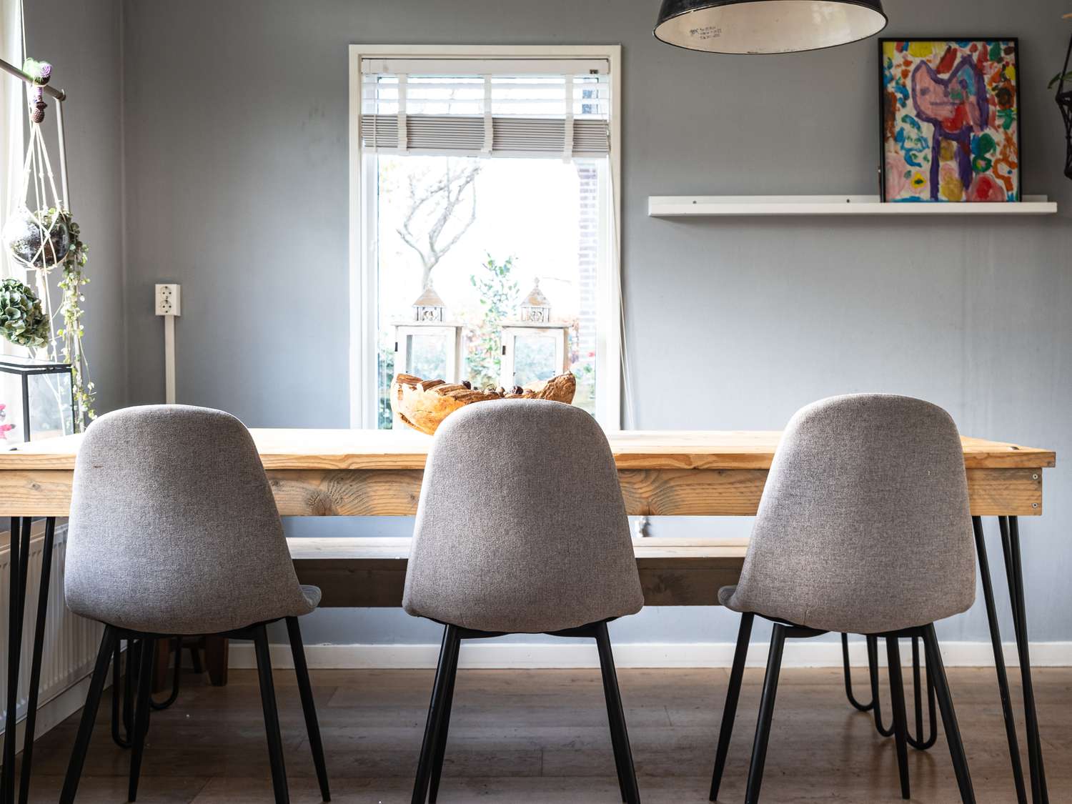 ein graues Esszimmer mit grauen Stühlen und Holztisch