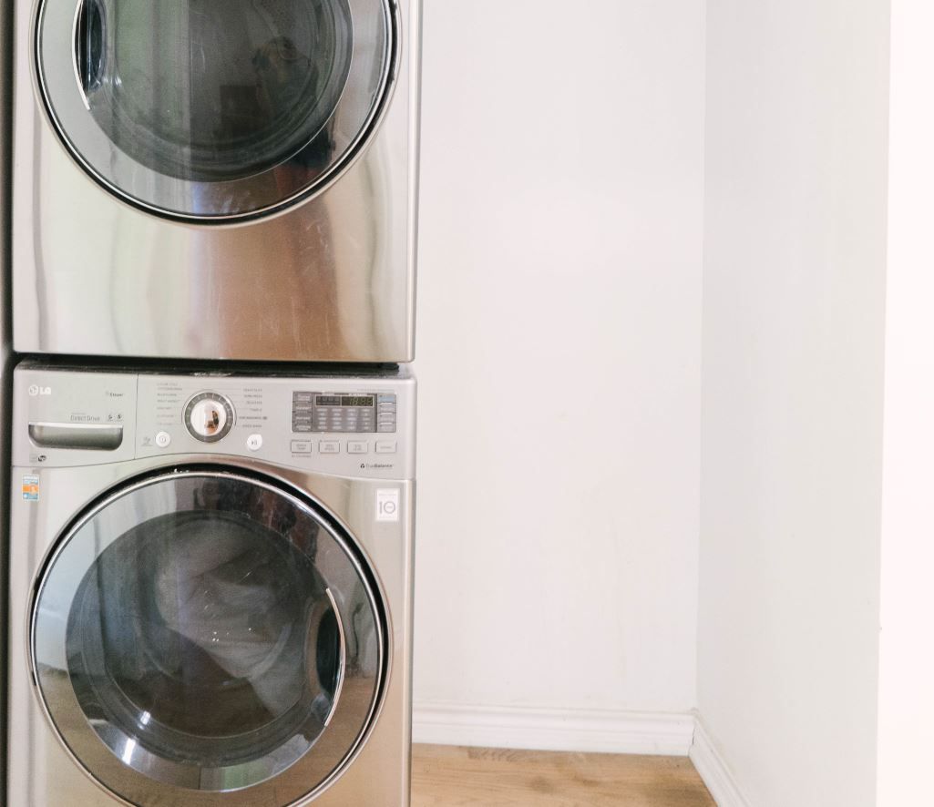 Armário de lavanderia com lavadora e secadora empilhadas
