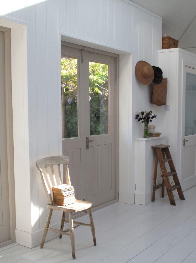 Habitación blanca con puerta interior pintada de seta