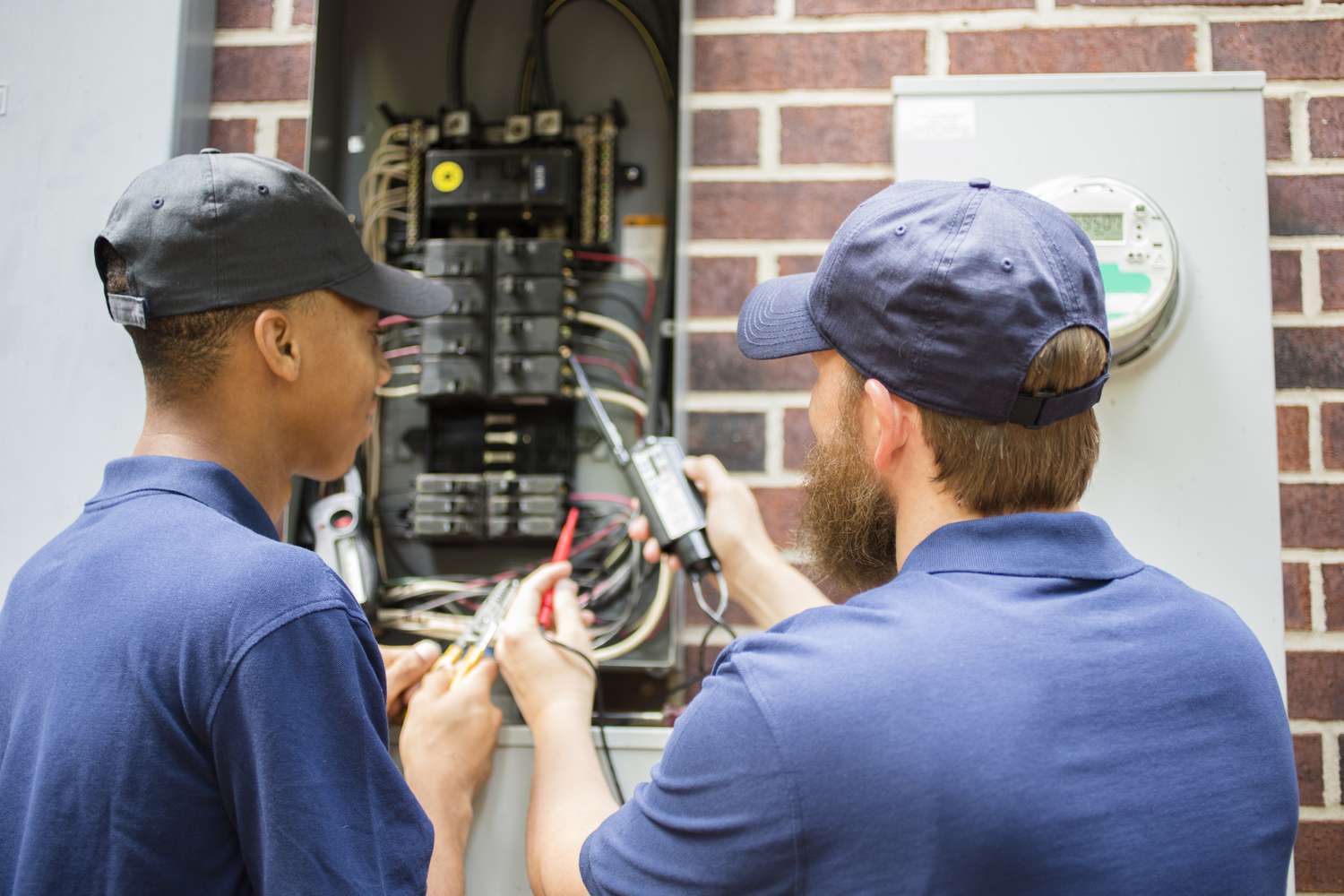 Repairmen, electricians repairing home breaker box