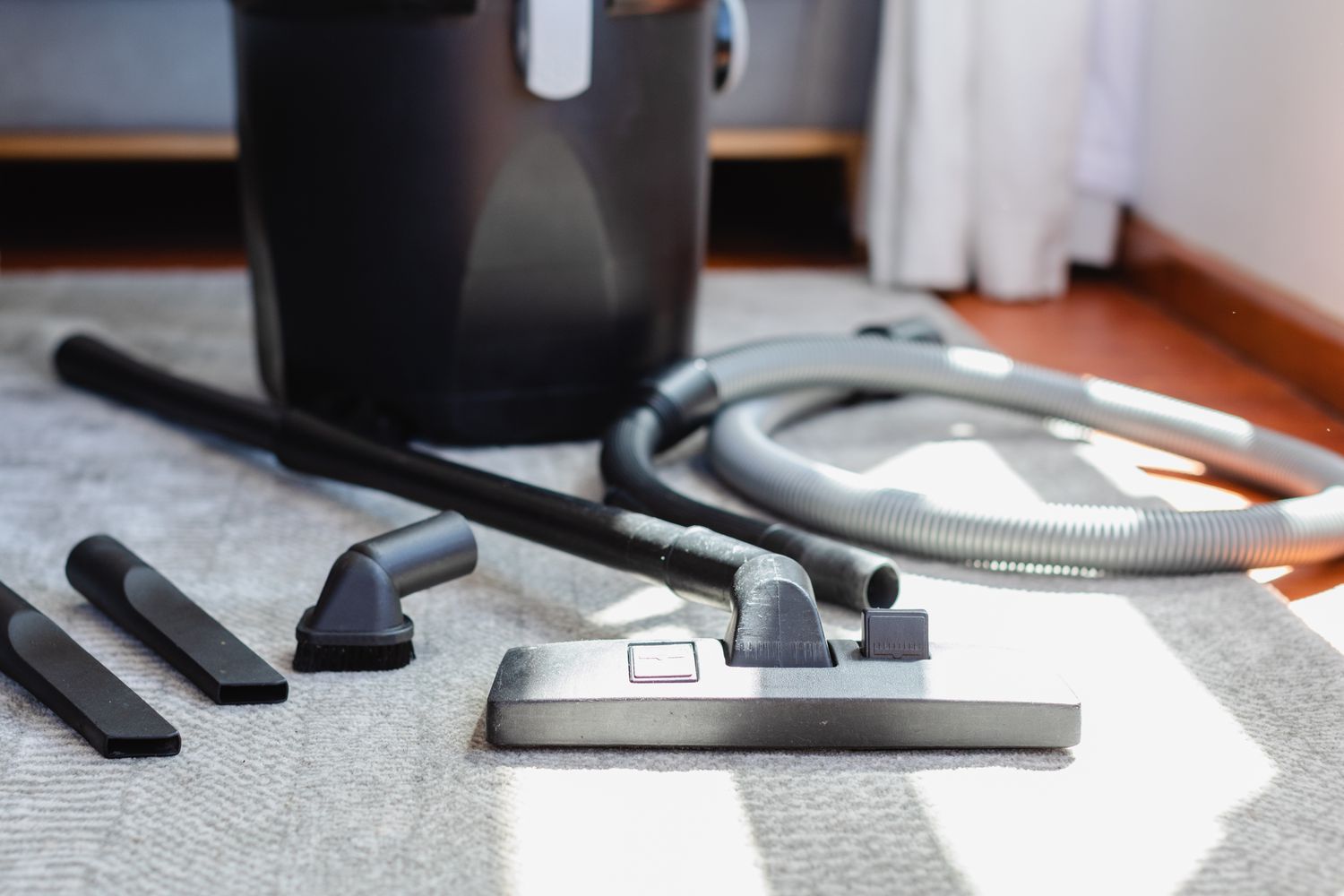 Aspirateur vertical avec réglages du tuyau posé sur moquette