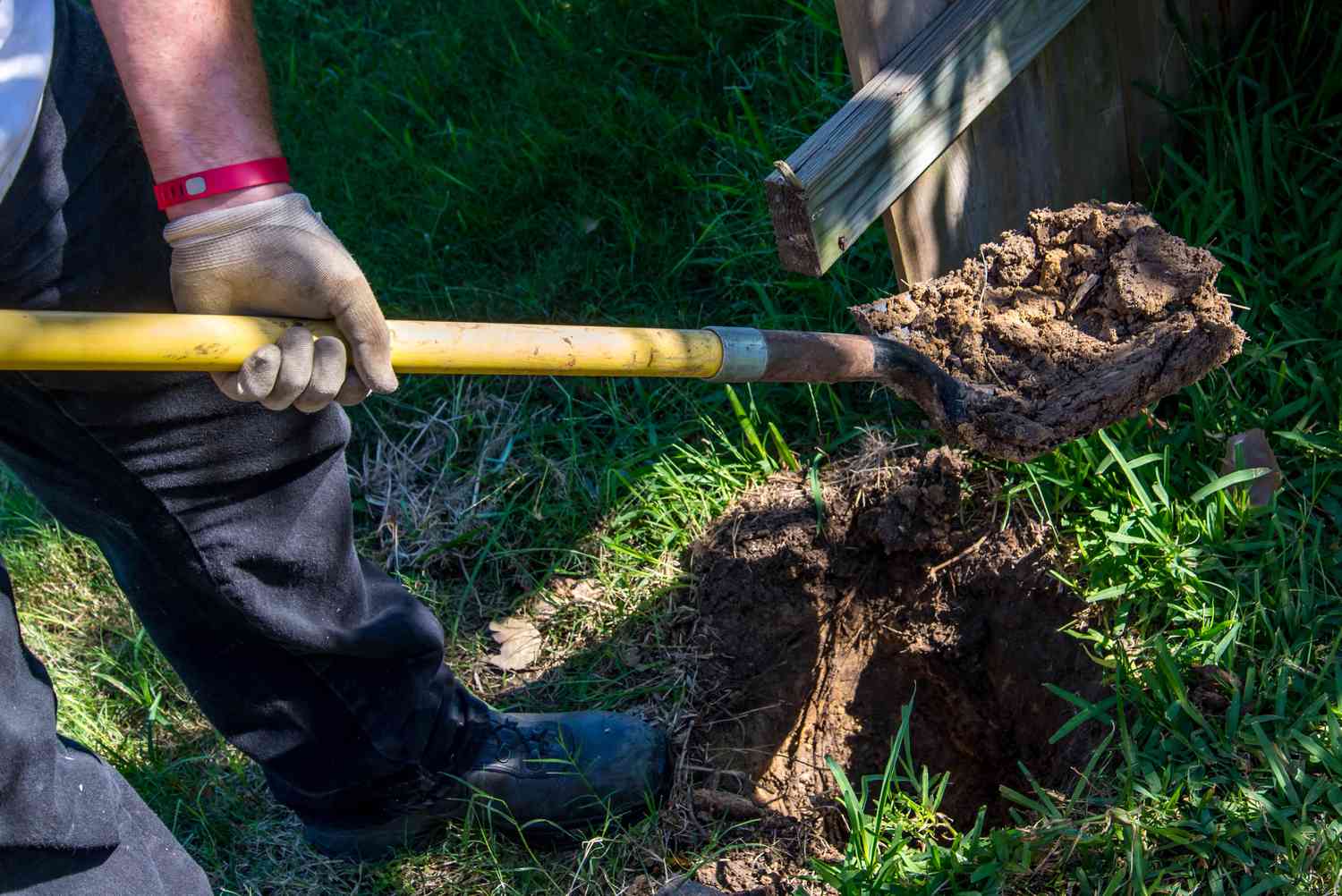 Mann gräbt Loch für Pfosten
