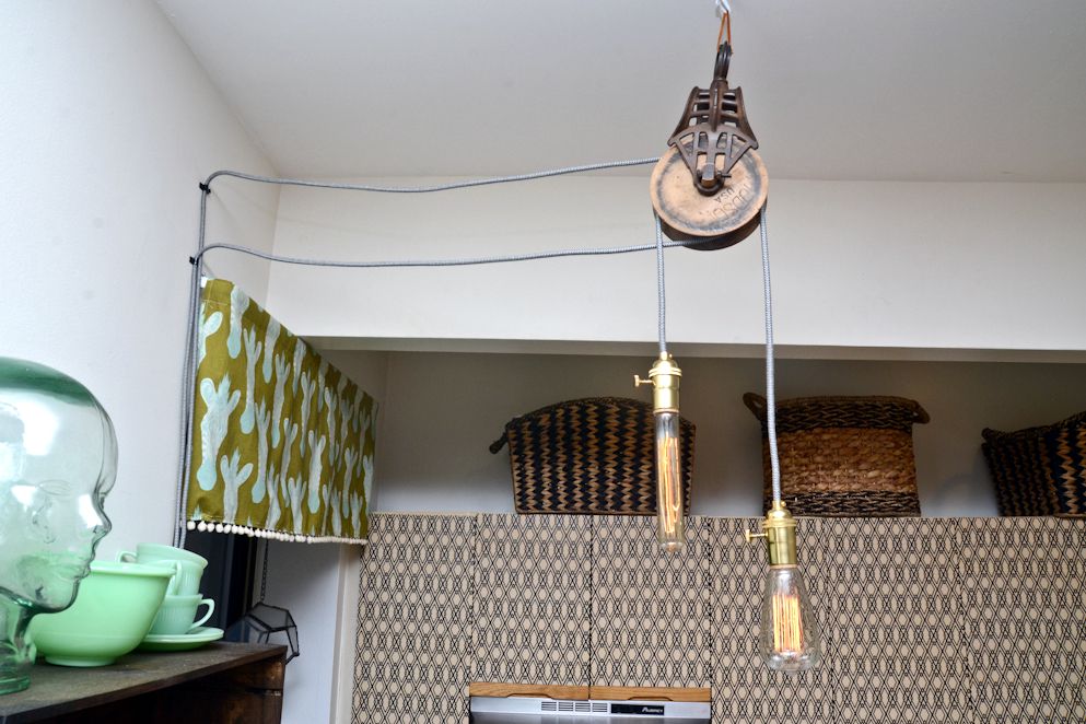 Barn pulleys repurposed as hanging lights with exposed filament bulbs