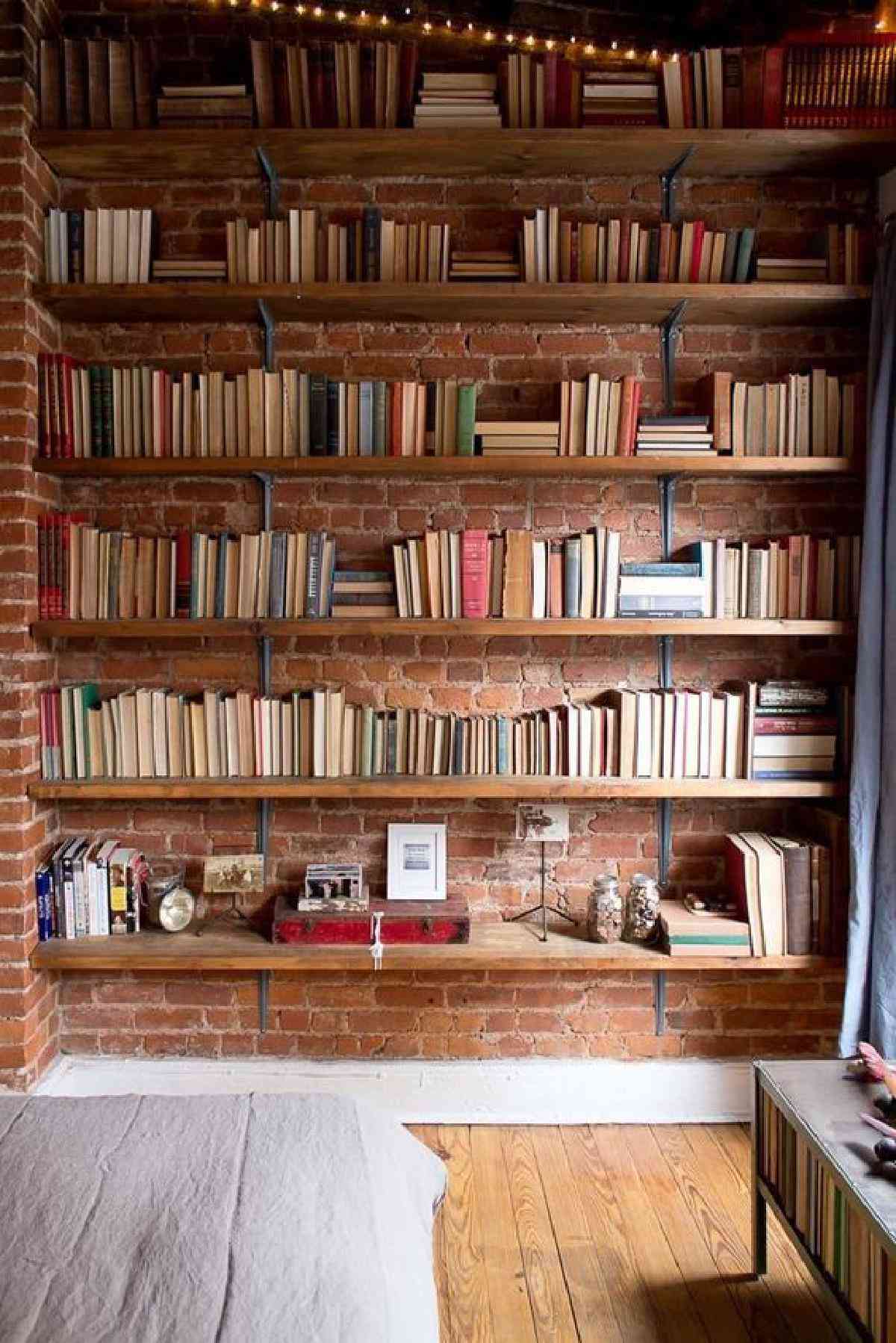 Backsteinwand mit freiliegendem Bücherregal