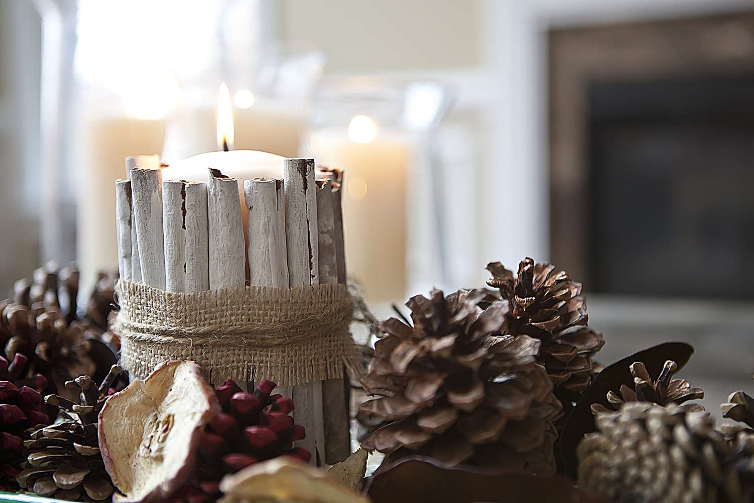 centro de mesa con velas de canela en rama y piñas