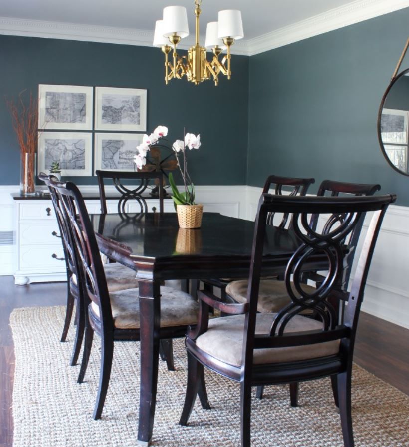 Sala de jantar tradicional atualizada com paredes azuis ardósia, painéis brancos e móveis de madeira escura.