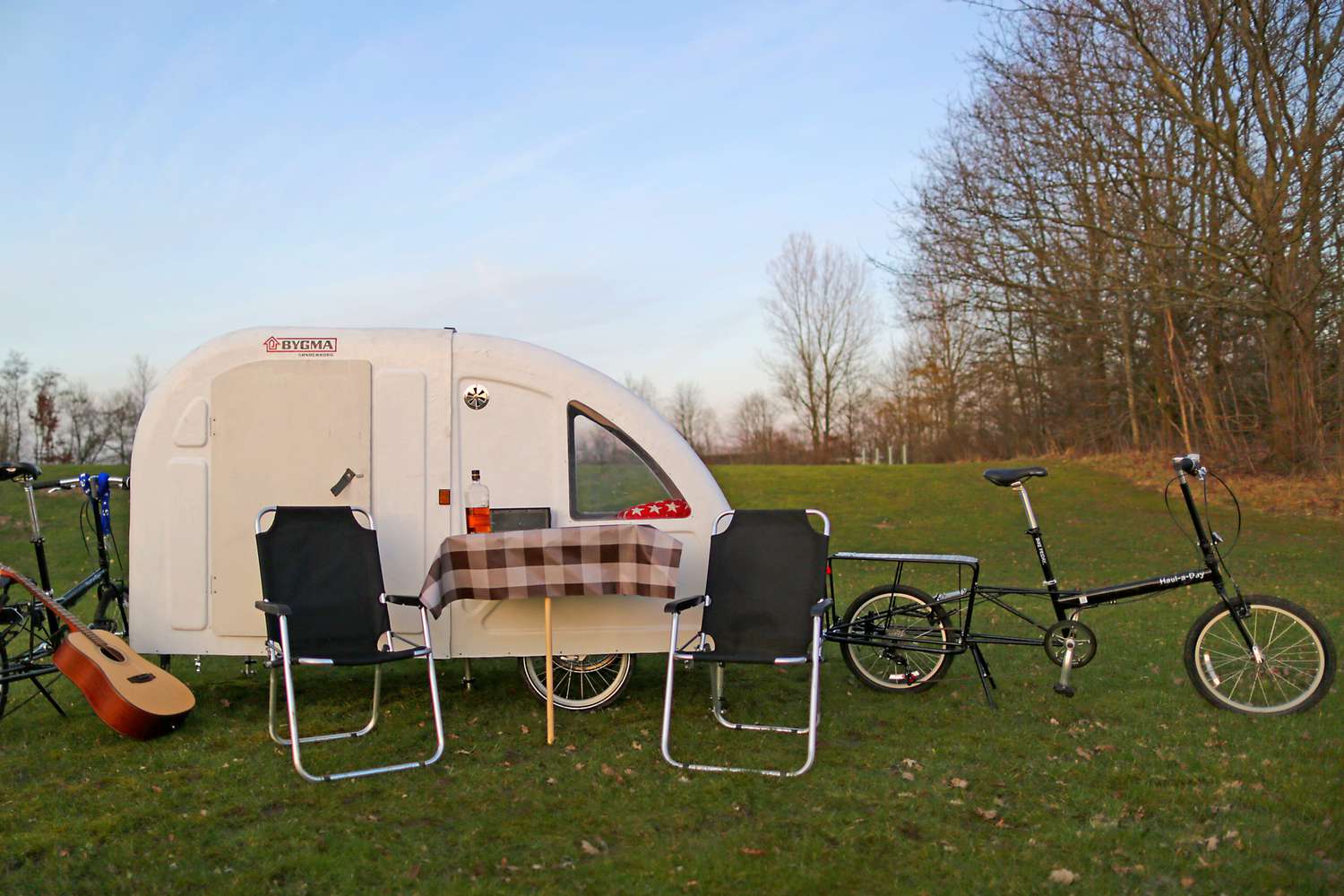A Wide Path Camper with bicycles and a guitar