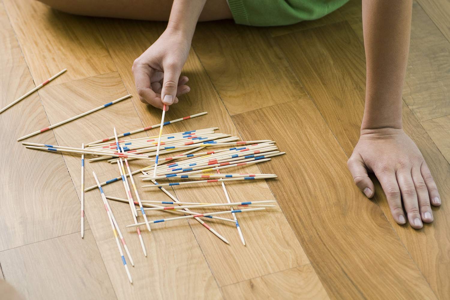 Frau spielt mit Stöcken auf dem Boden