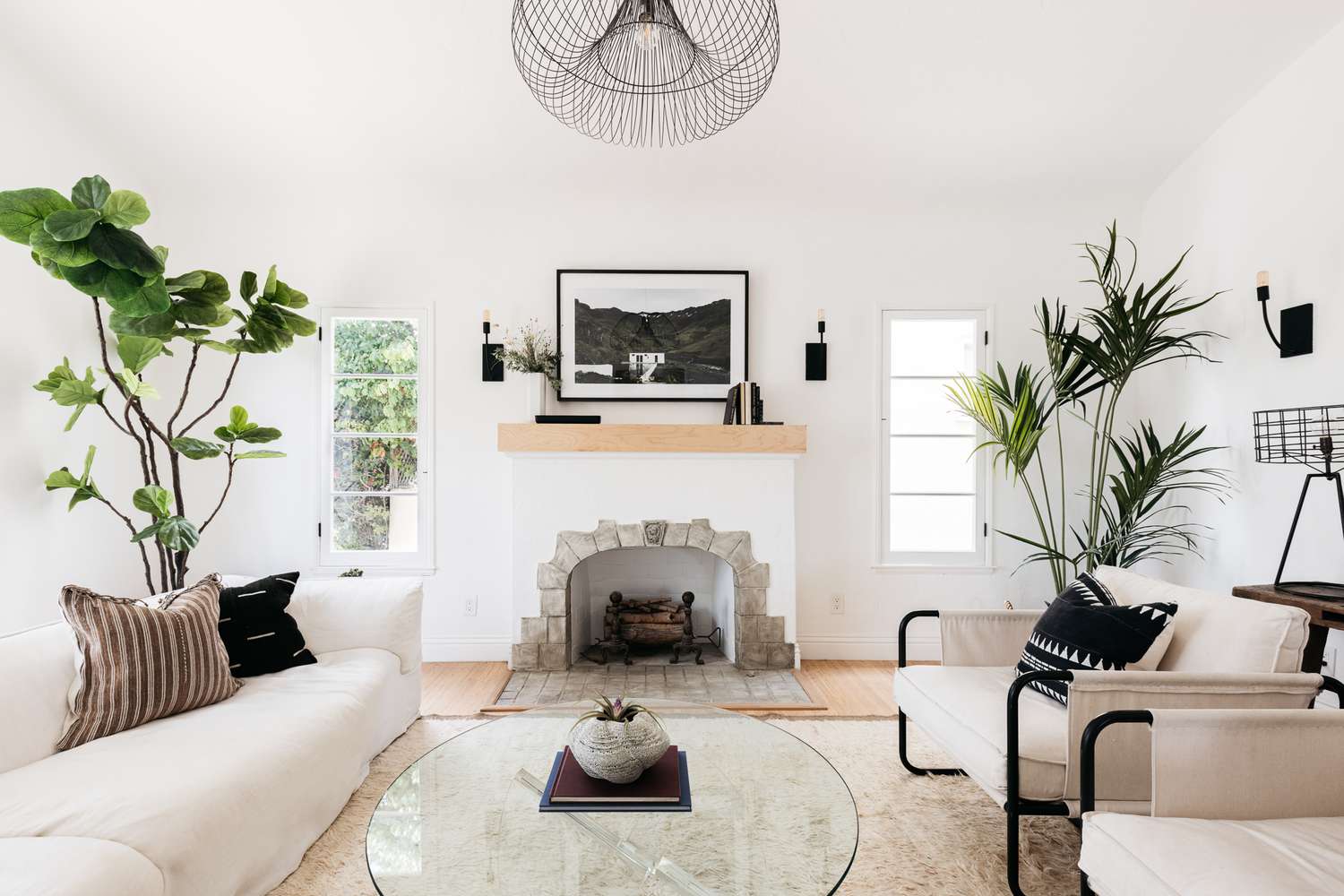 Salon avec cheminée entouré d'un décor blanc et de plantes d'intérieur