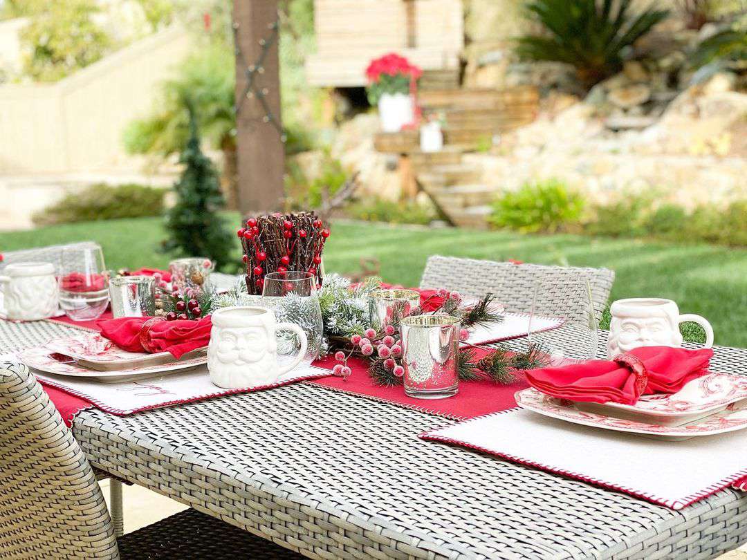 Ein Tisch im Freien, dekoriert mit rotem und weißem Weihnachtsschmuck.