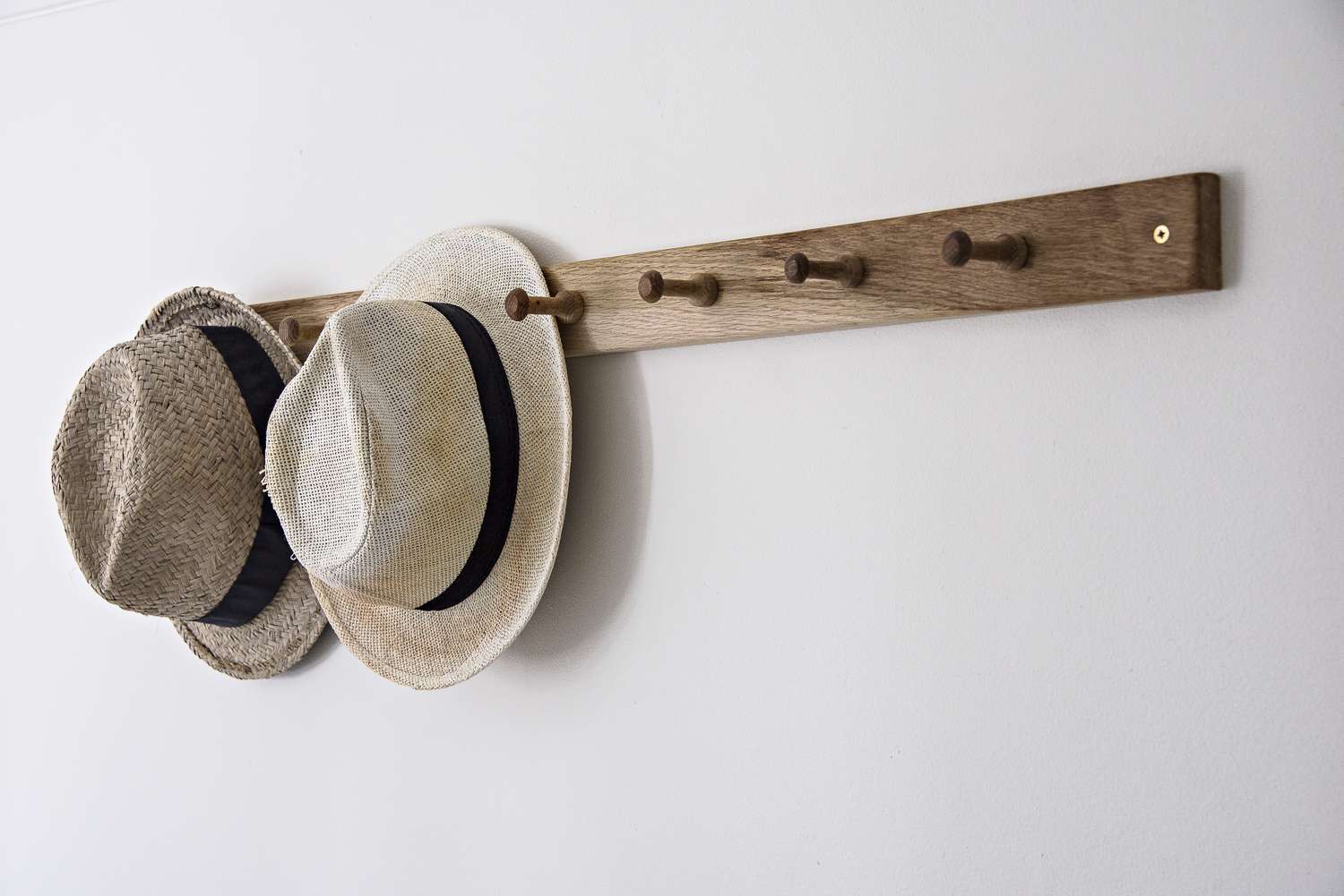 Chapéus pendurados em gancho na parede do banheiro