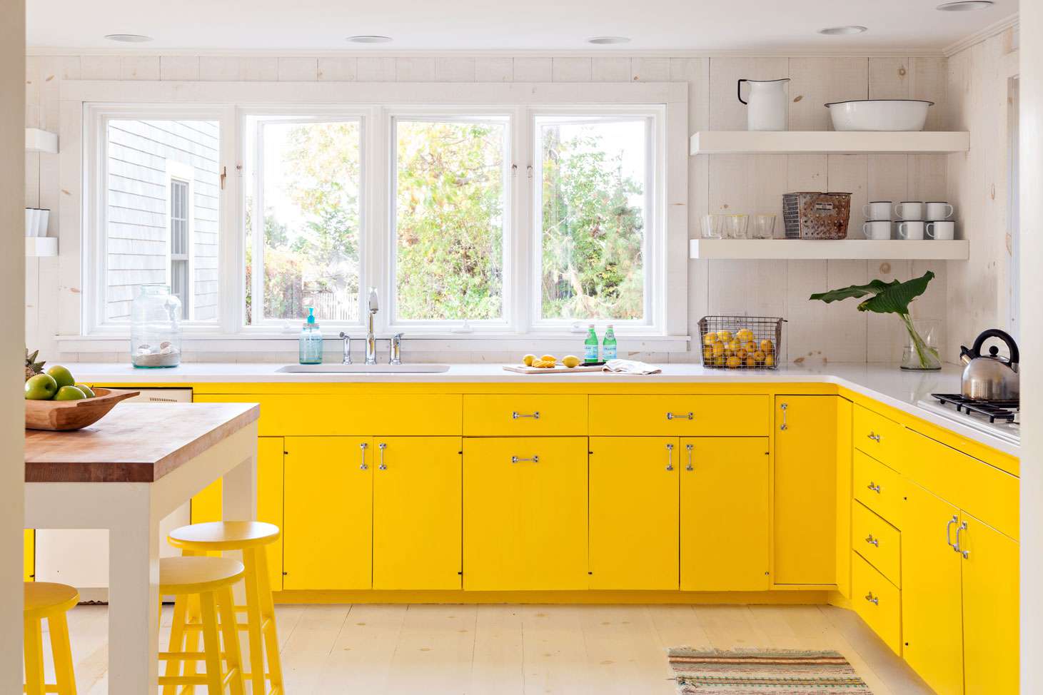 Cozinha de fazenda com armários amarelos brilhantes sob o balcão