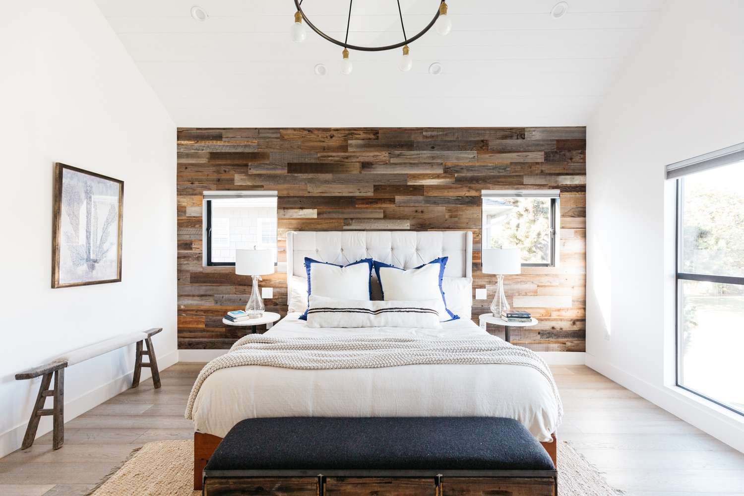 Planches de bois mélangées couvrant le mur d'accent dans la chambre à coucher lumineuse 