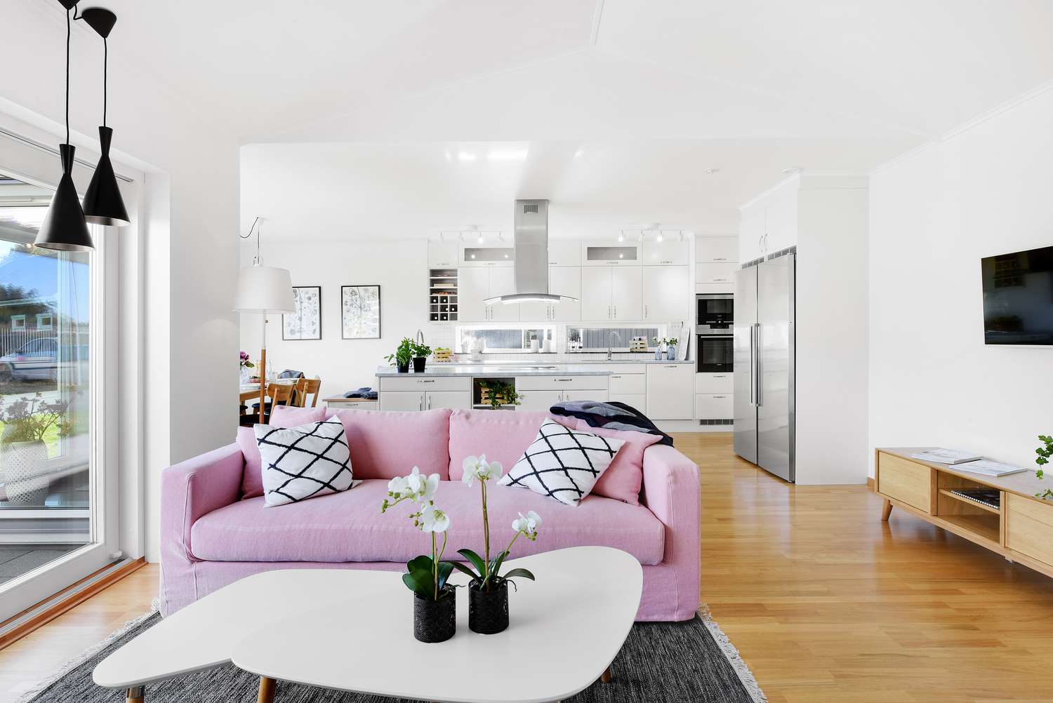 Open floor plan home with pink couch in the living room area
