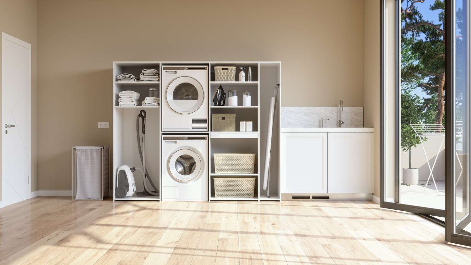 Waschküche mit beiger Wand und Parkettboden mit Waschmaschine, Trockner, Wäschekorb und gefalteten Handtüchern im Schrank.
