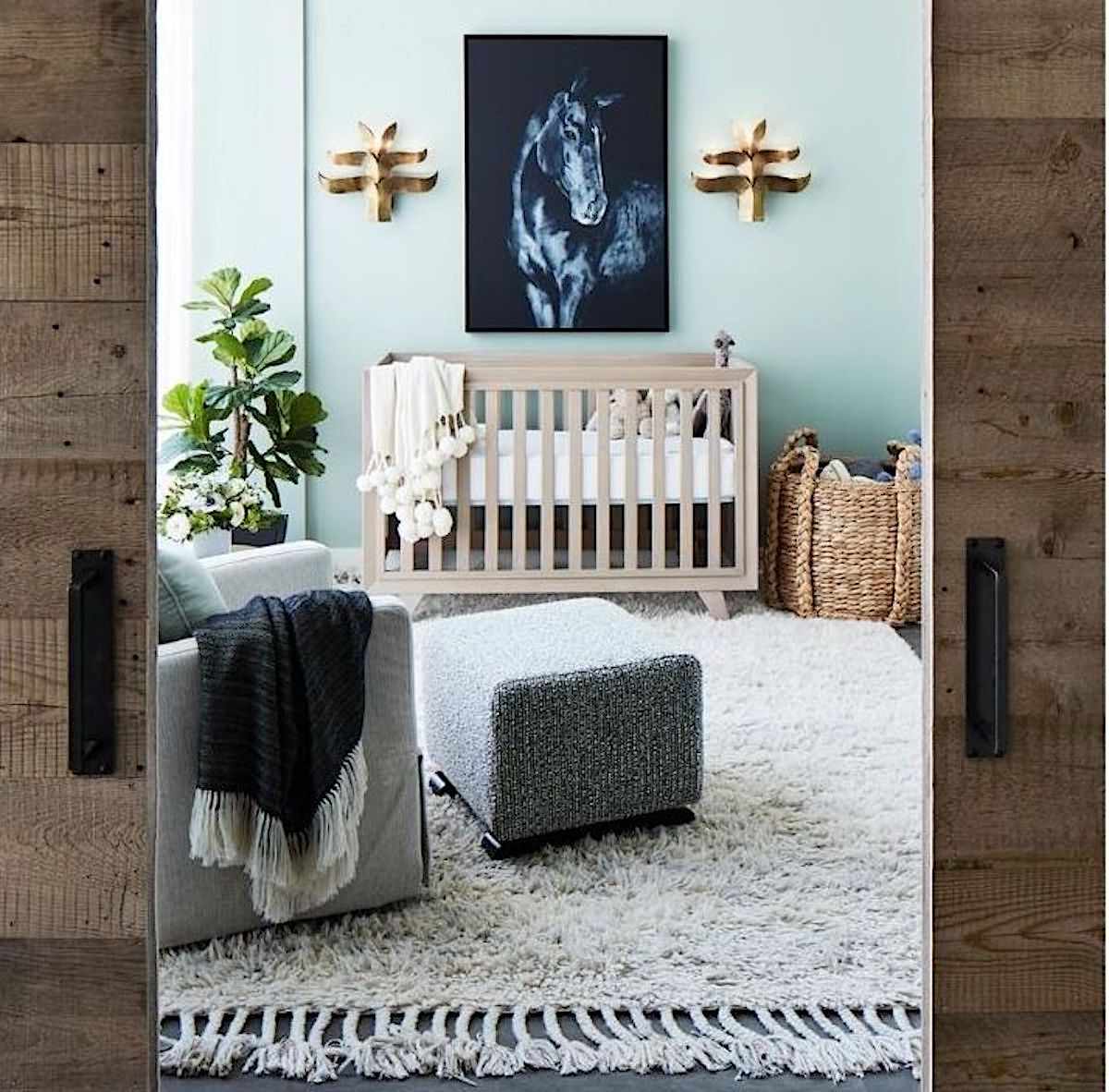 blue nursery with tan crib and artwork of blue horse hanging above