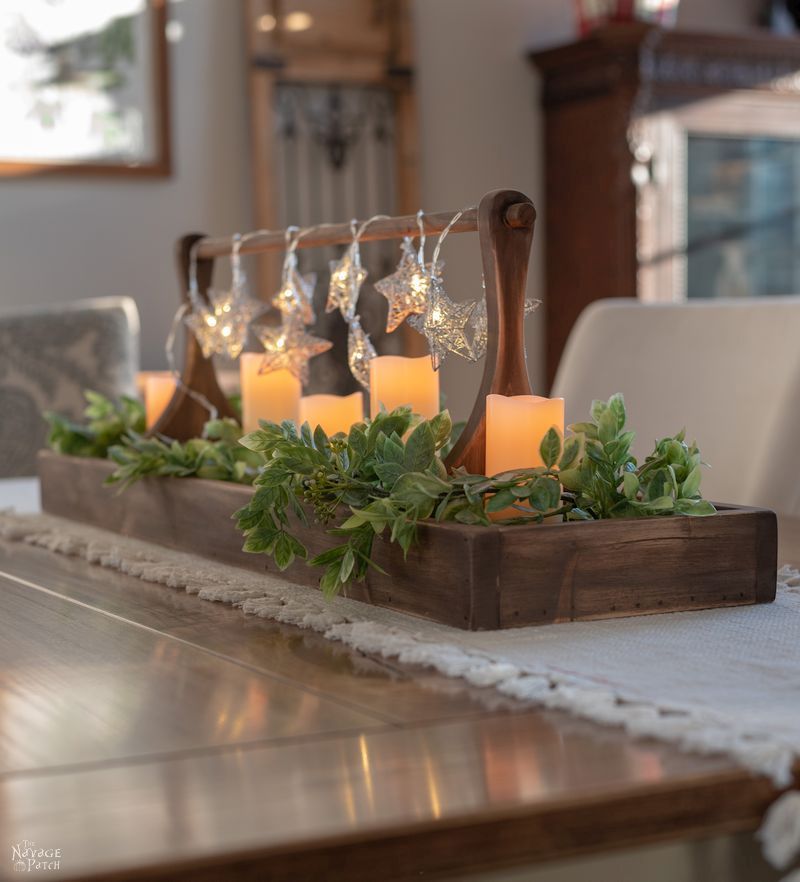 Un plateau avec de la verdure et des lumières sur une table