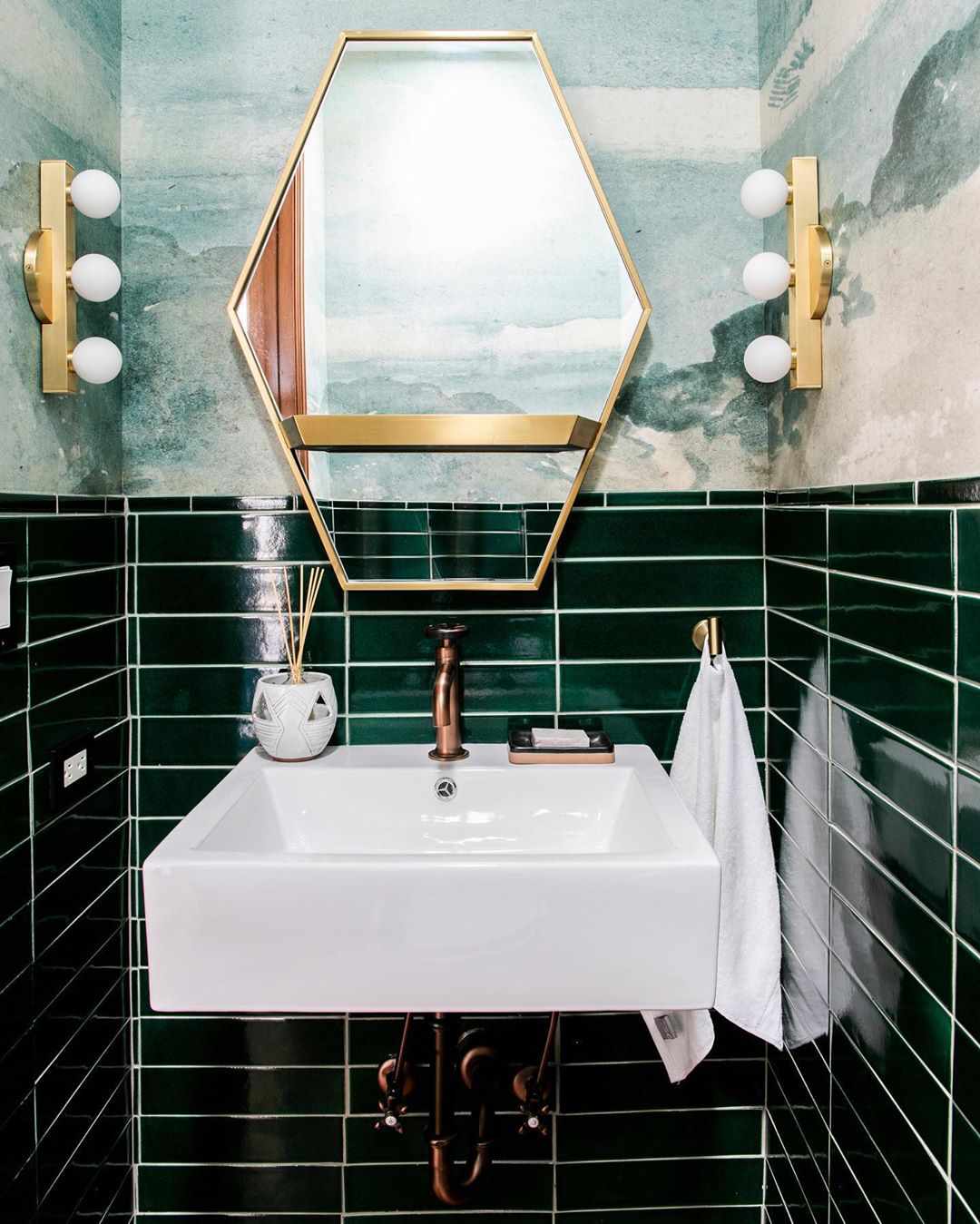 Azulejos y papel pintado verde oscuro en un baño