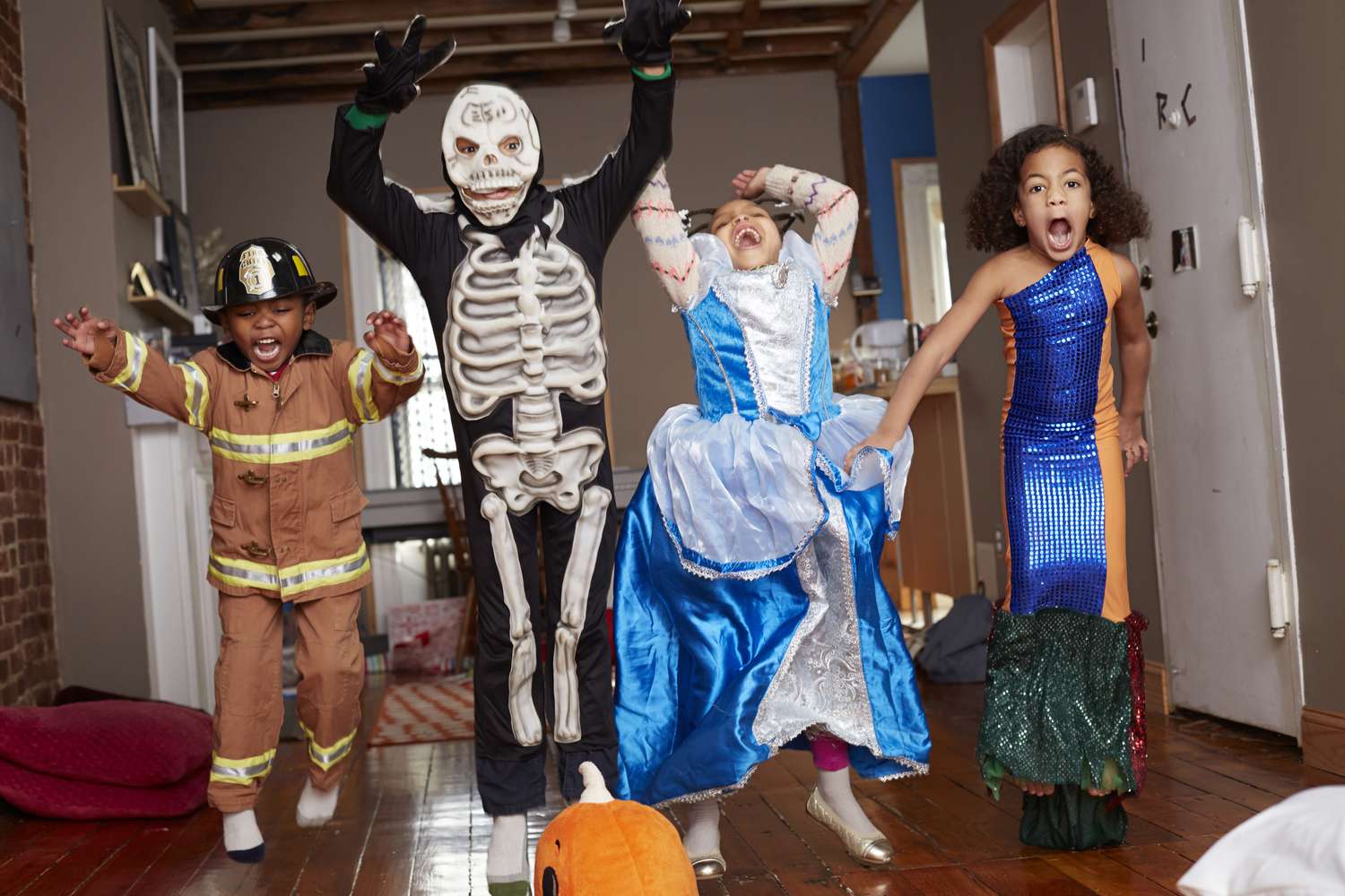 Kinder in Halloween-Kostümen springen vor Freude