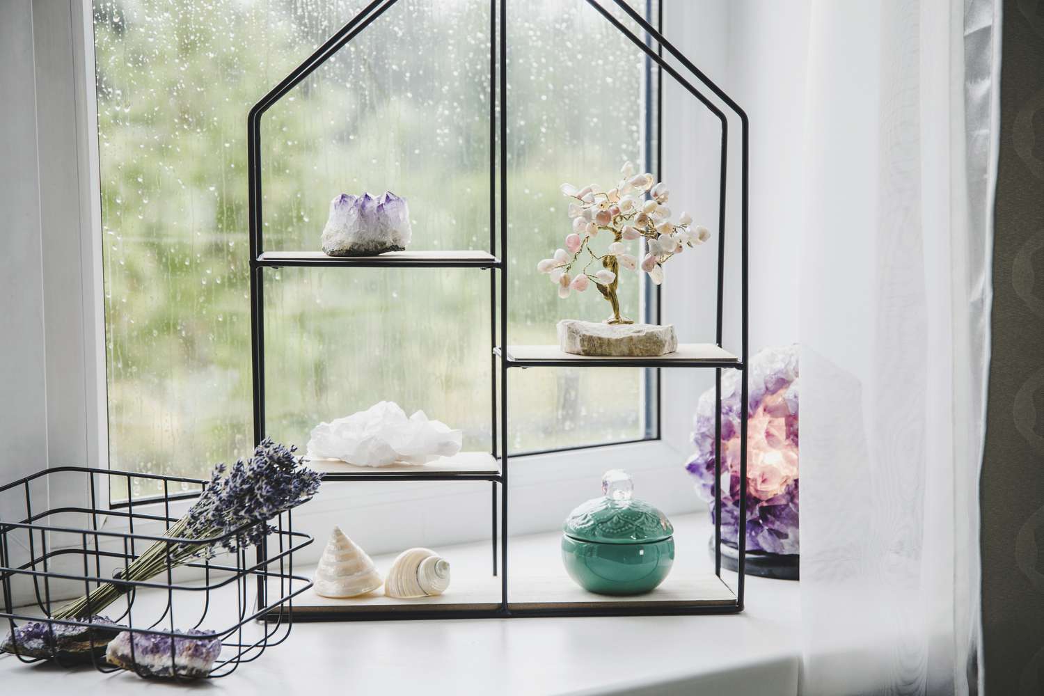 Minimalistisches Stillleben mit modernem Metalldraht und Holzregal auf der Fensterbank für die Heimdekoration. Spirituelles Interieur, halbedle Edelsteine auf dem Display.