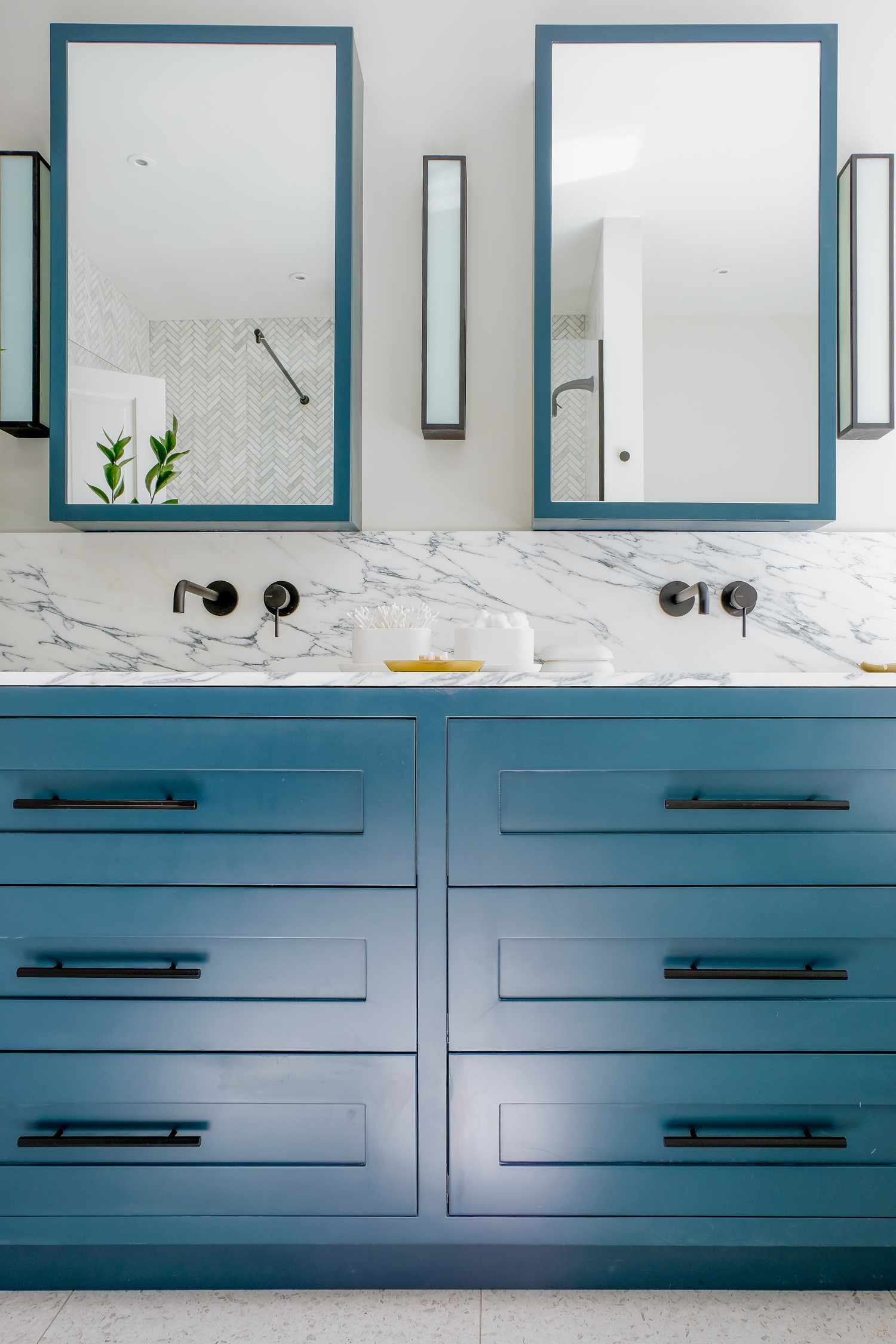 bright bathroom with two sinks and a blue vanity