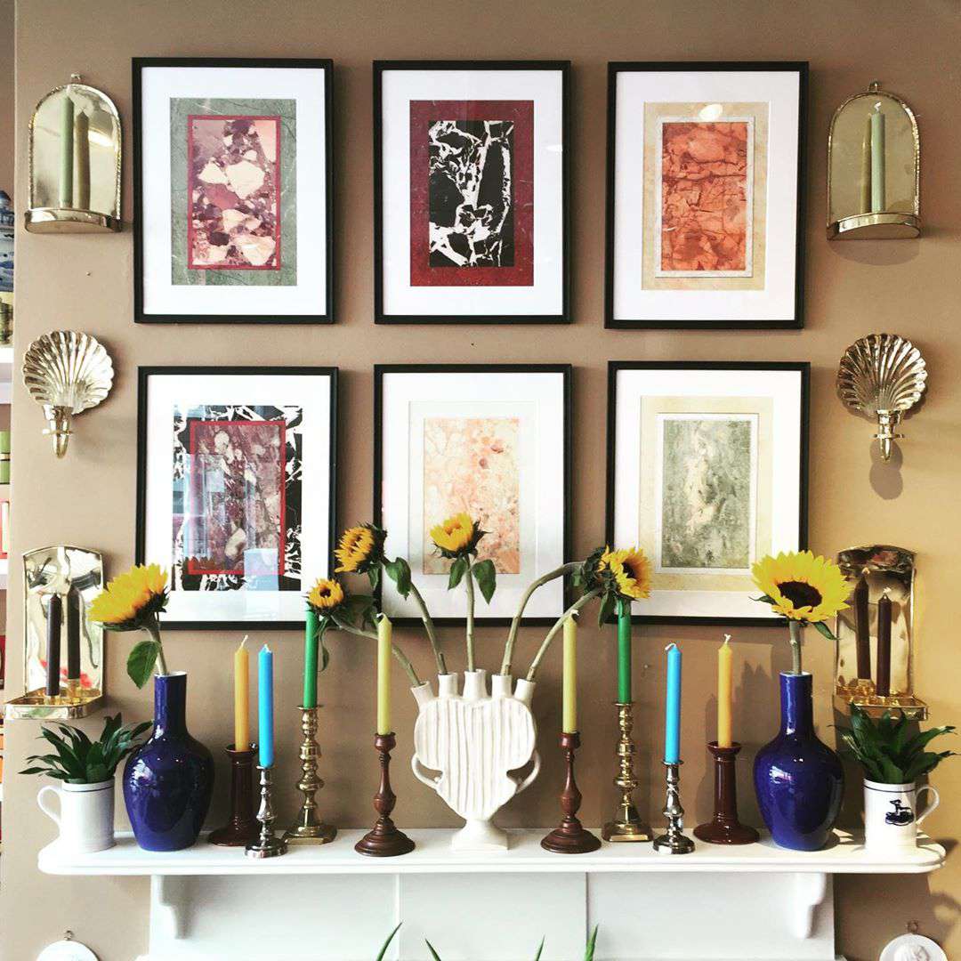 Light brown wall with framed pictures on it