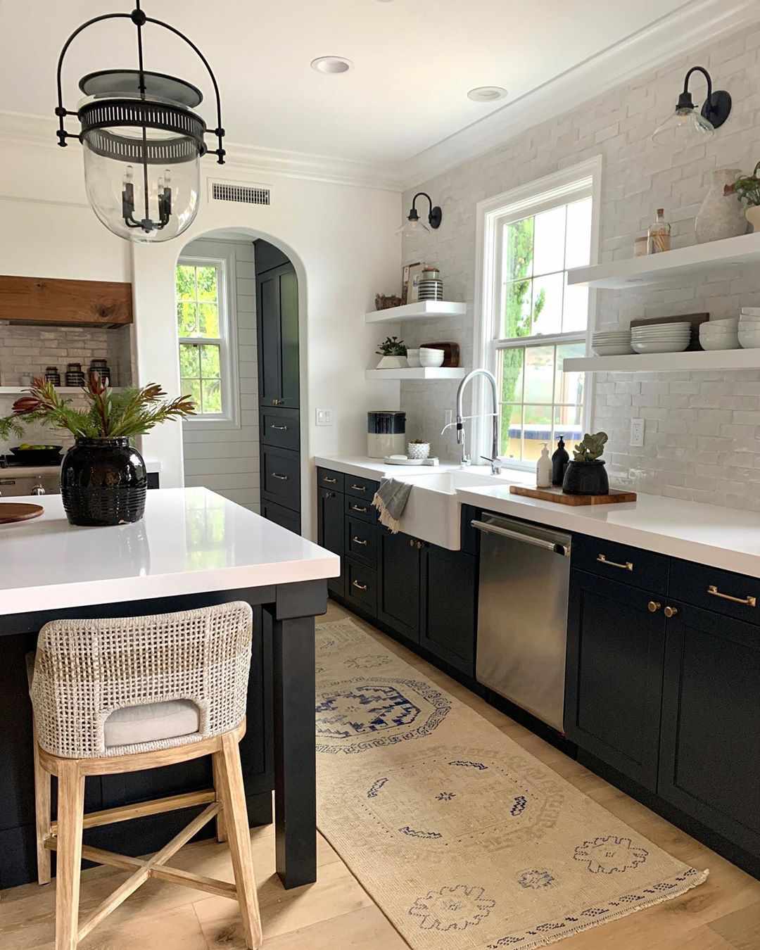 Cocina con encimeras de terrazo blanco y armarios negros 