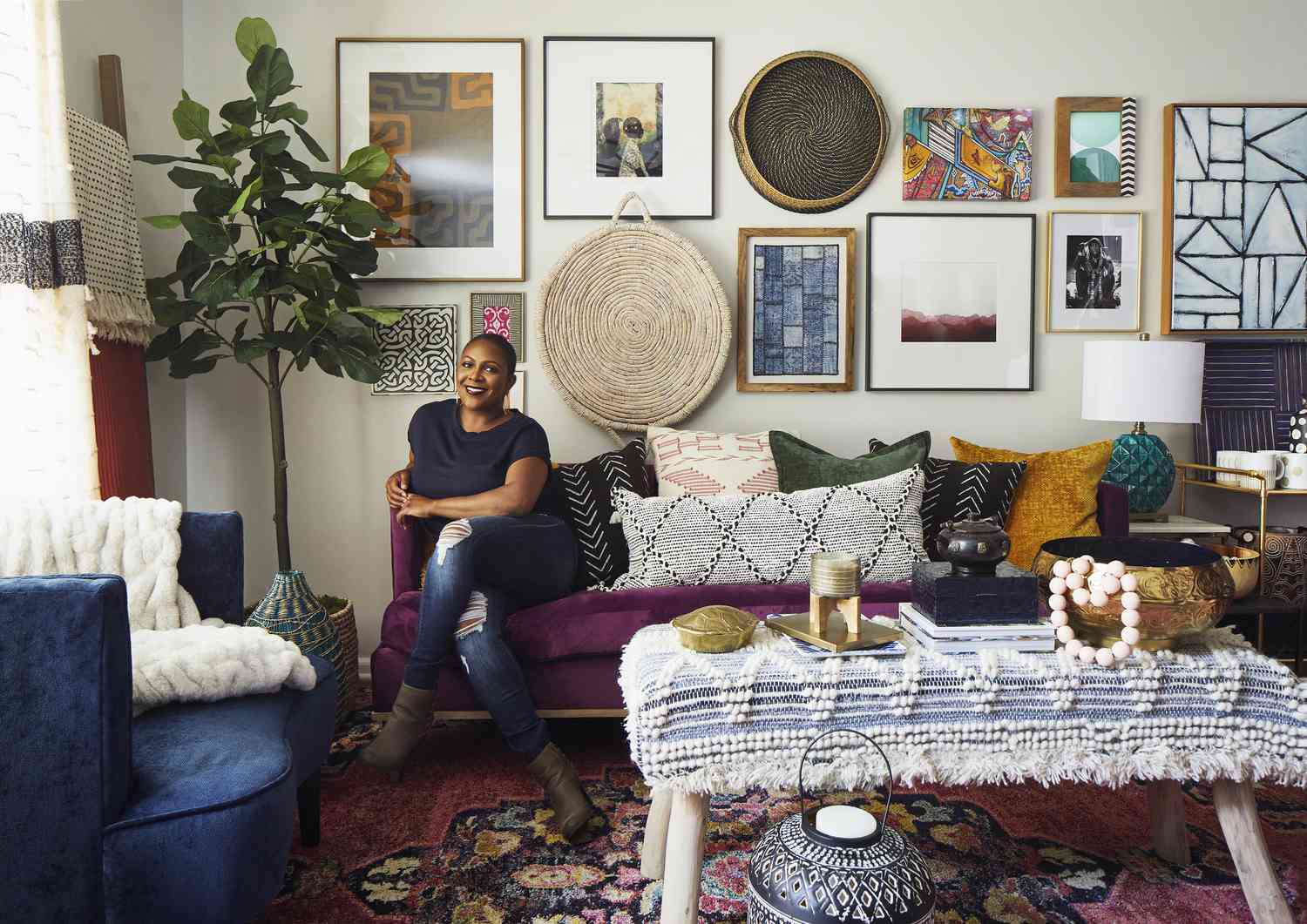 Beth Diana Smith posiert auf einer lila Couch in einem Raum mit Boho-Chic-Dekor