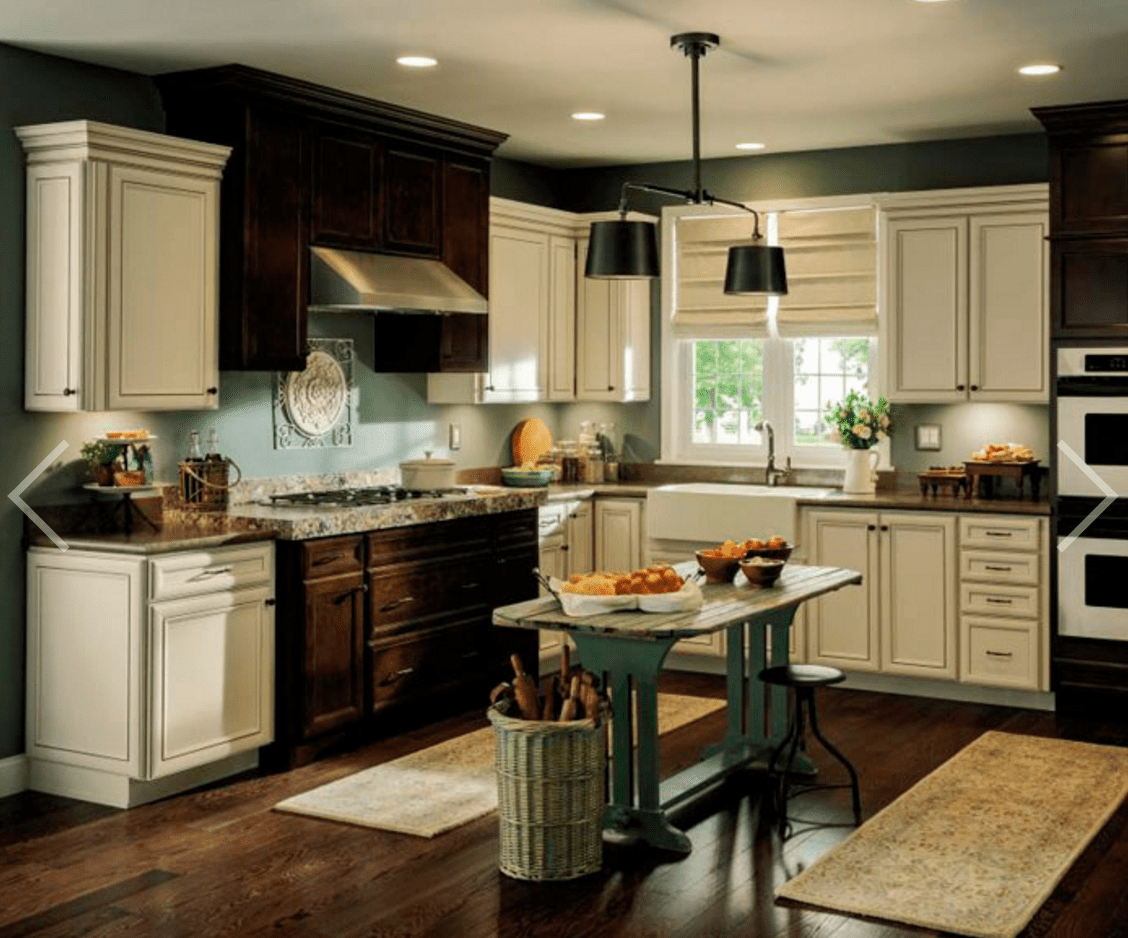 Gemütliche Küche mit dunklen Wänden und weißen Schränken und Holzböden